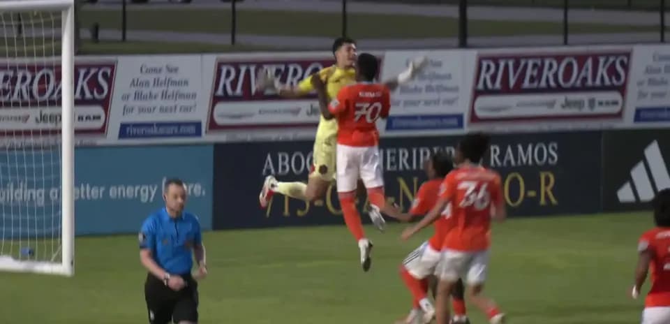 Goalkeeper jumping to catch the ball during match