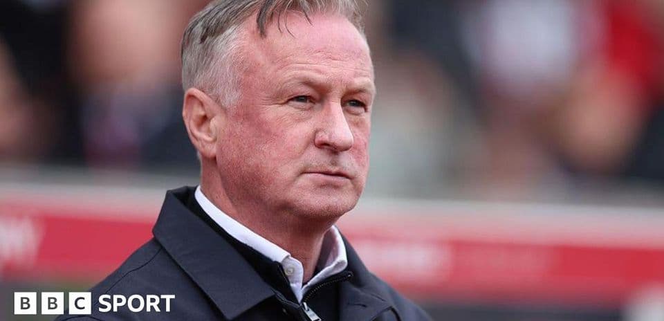 Football manager observing from the sidelines during match