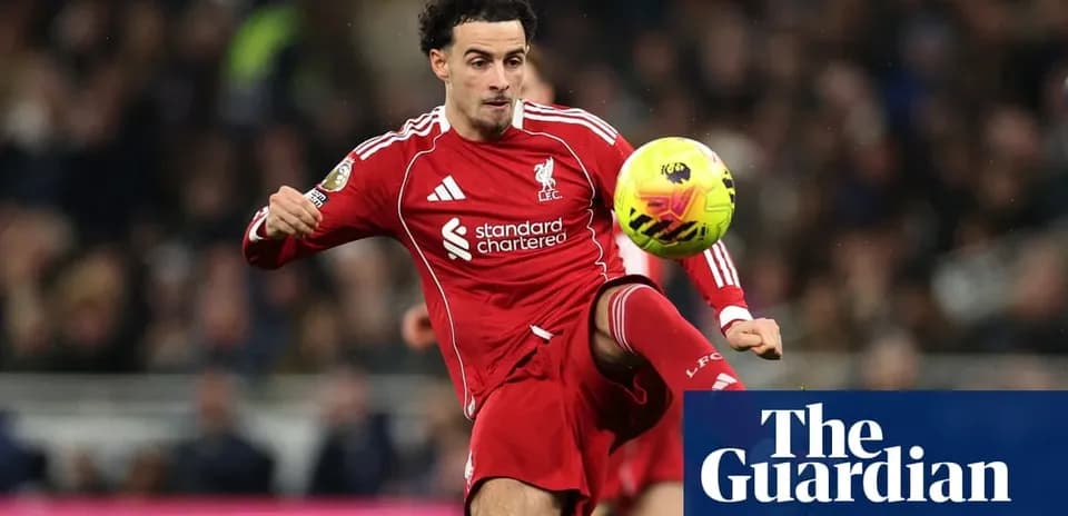 Liverpool player kicking ball during match action