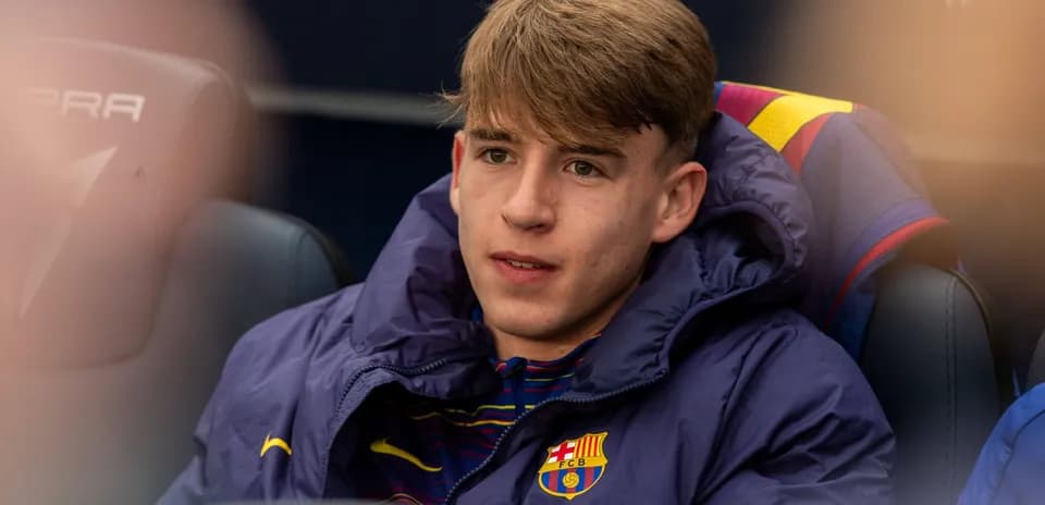 Young player sitting on bench in team jacket