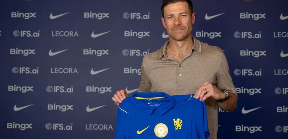 New coach holding Chelsea jersey at press conference