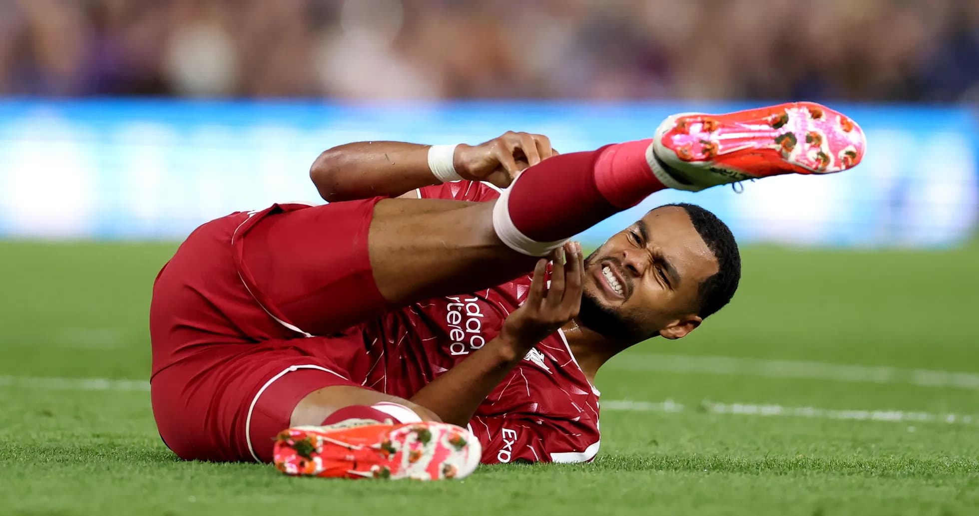 Player lying on field with injured leg during match