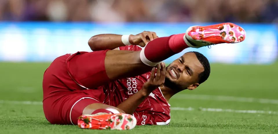 Player lying on field with injured leg during match