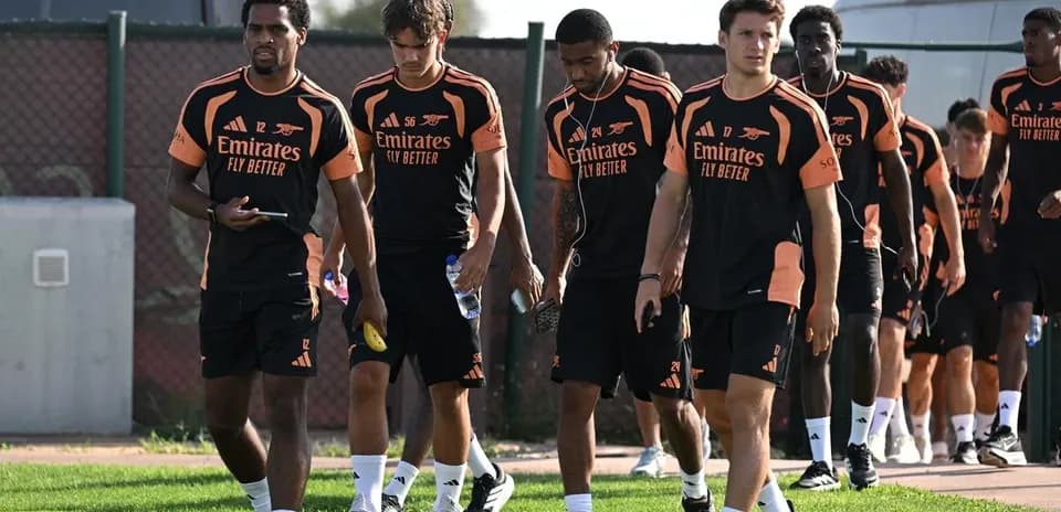 Arsenal players walking on training ground in uniforms