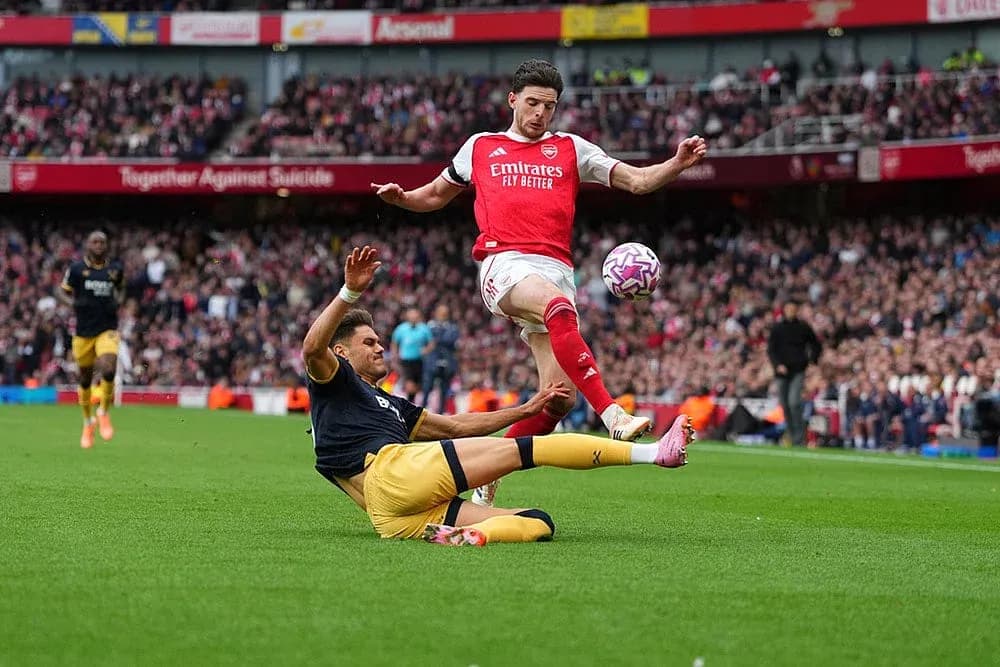 Arsenal player dodging a tackle during match