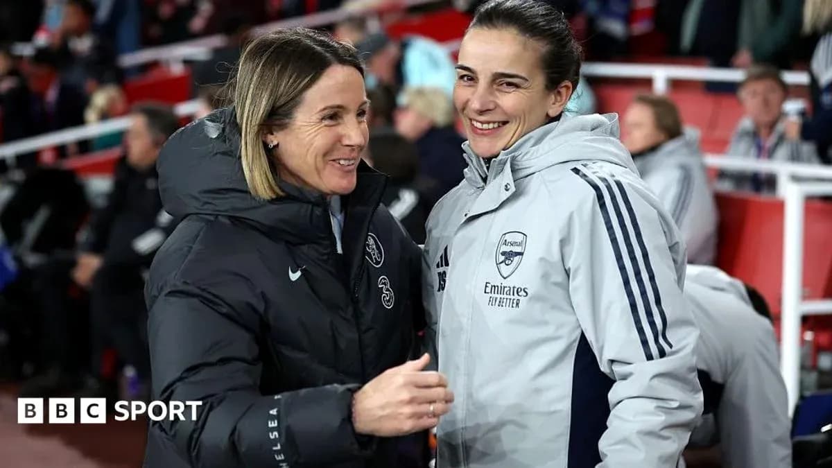 Two coaches chatting on the sidelines during match