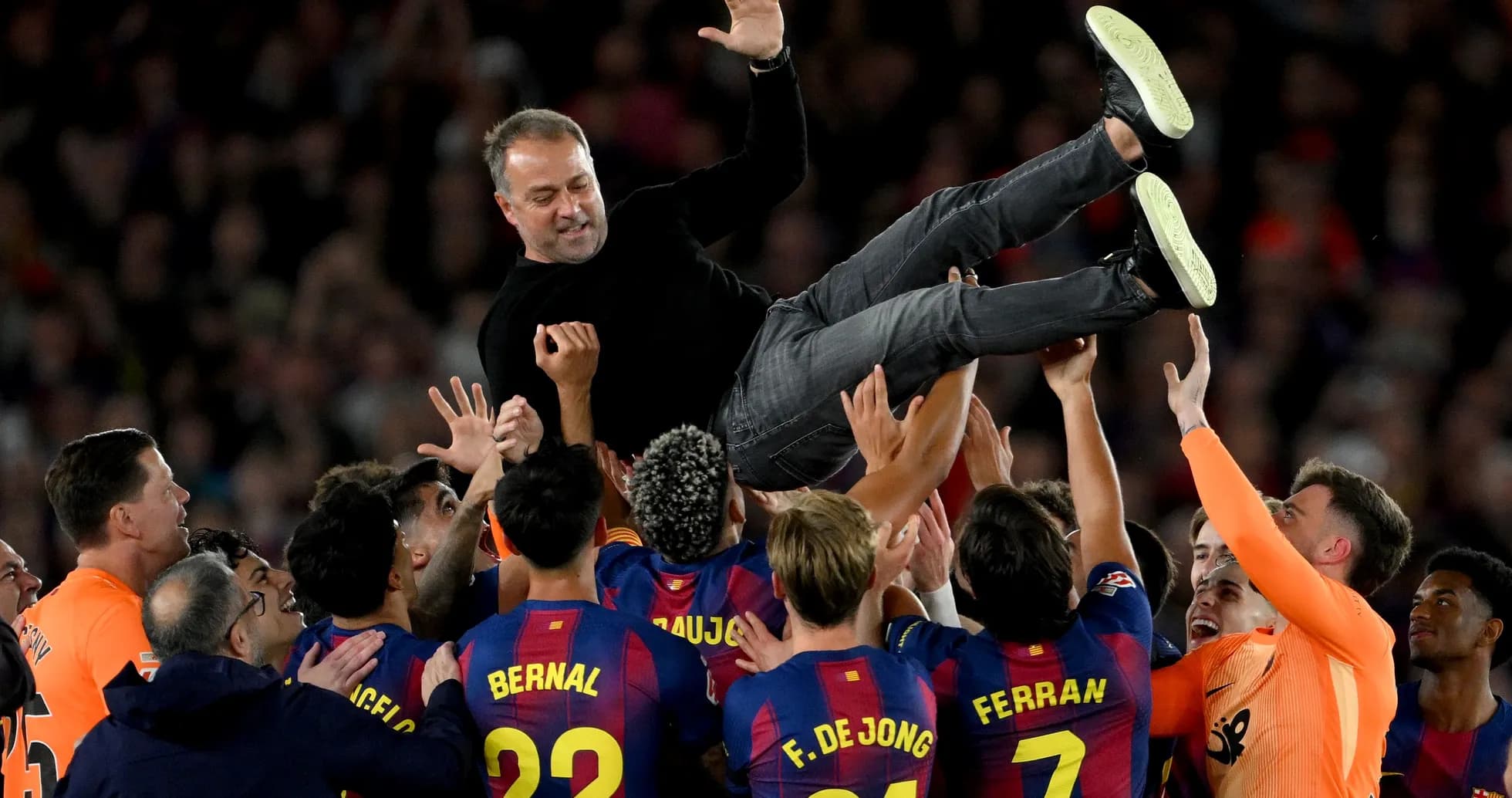 Barcelona players lifting their coach in celebration