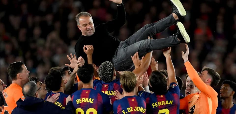 Barcelona players lifting their coach in celebration