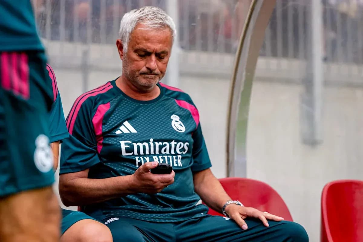Coach sitting on bench looking at phone