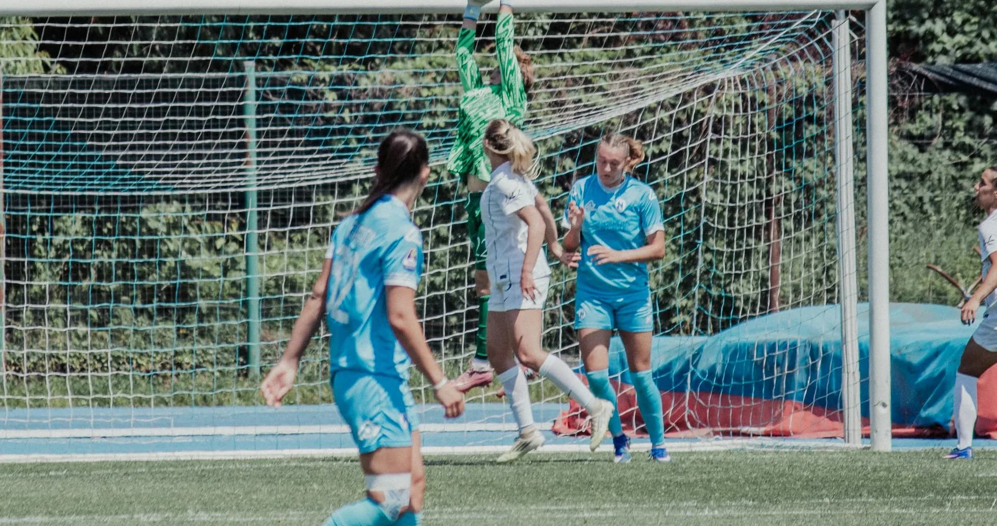 Goalkeeper catching ball during women's football match