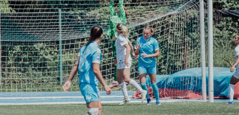 Goalkeeper catching ball during women's football match