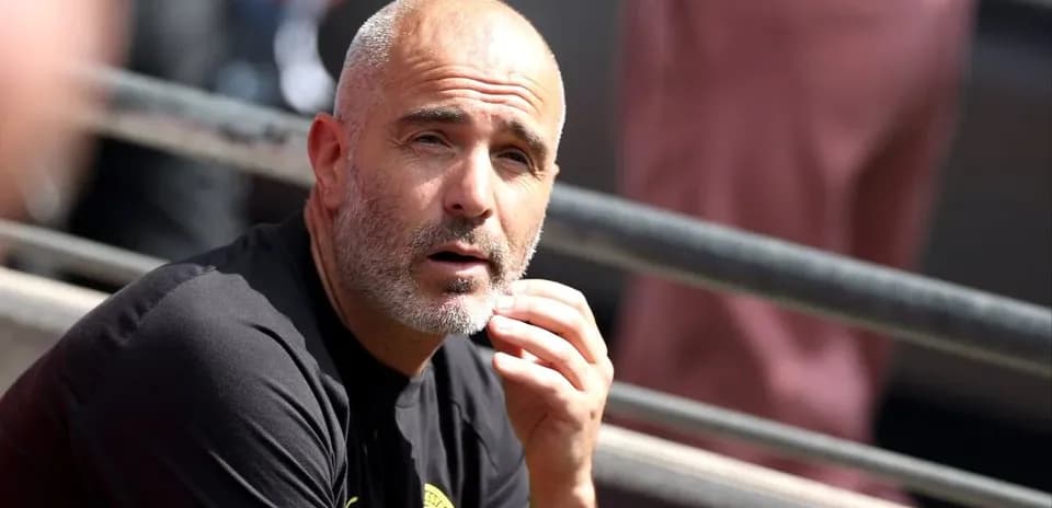 Coach sitting on bench during match