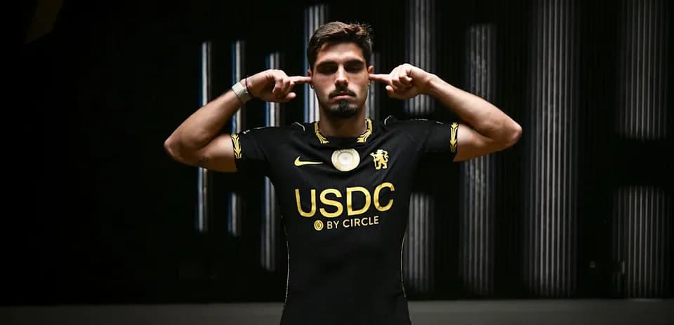 Player posing in black jersey with USDC logo