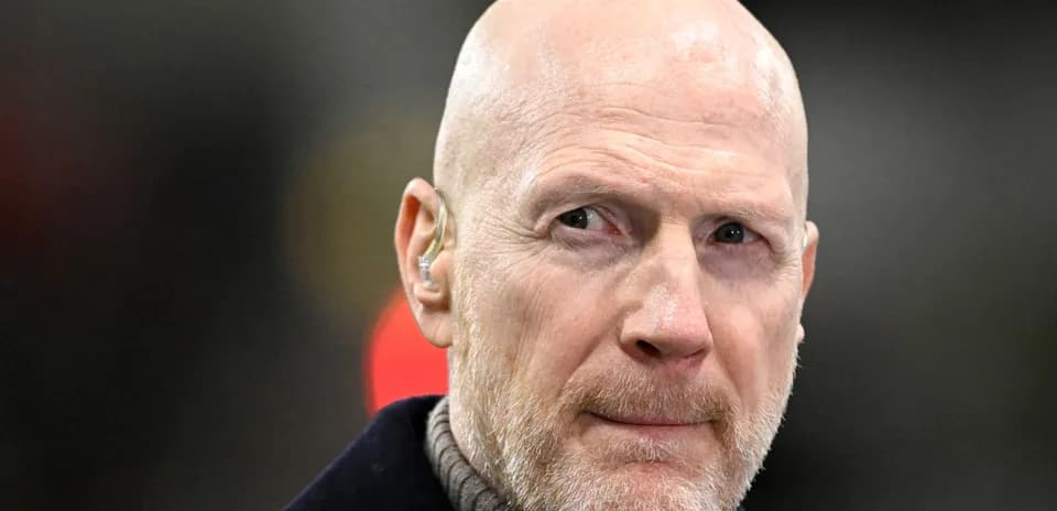 Man with bald head and beard wearing ear piece