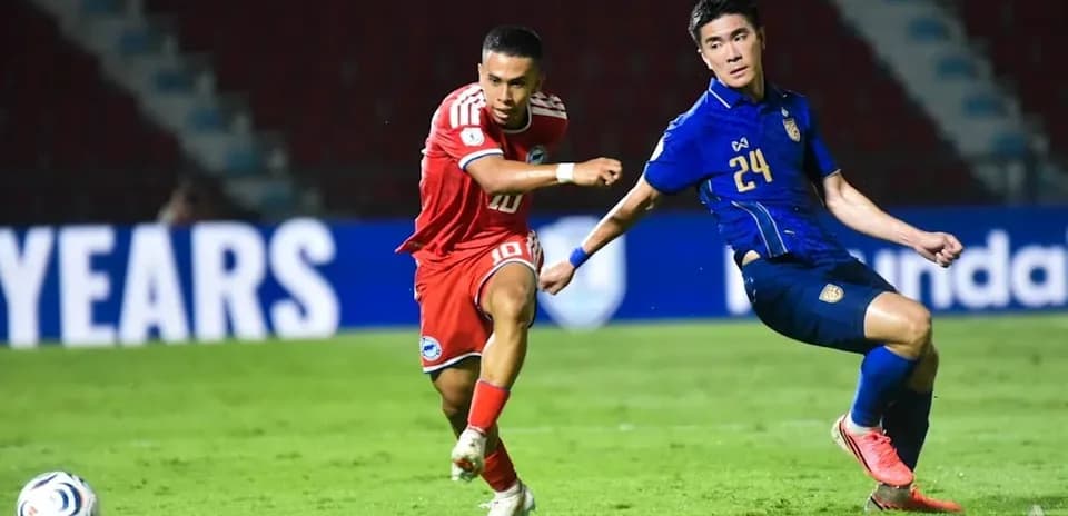 Player in red dribbling past defender in blue jersey