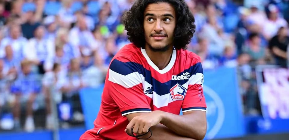 Player in Lille OSC kit sitting on pitch