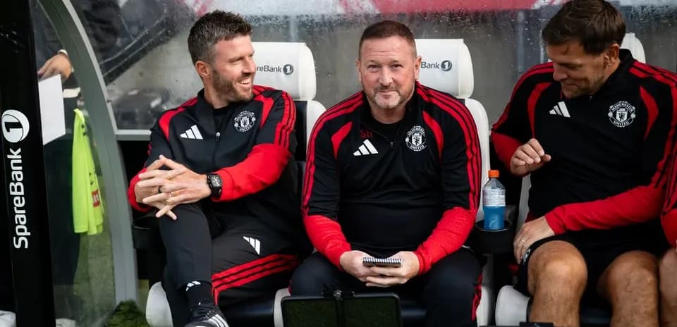 Coaching staff seated on Manchester United bench