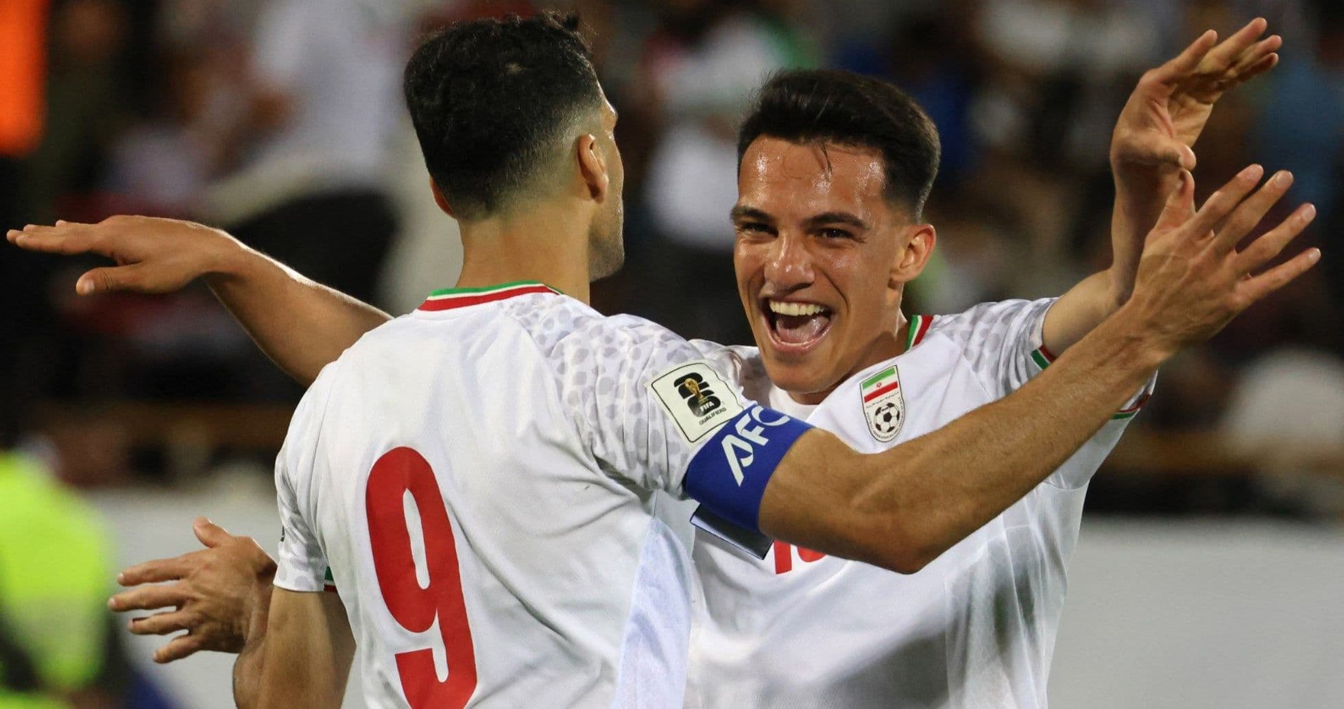Two Iranian players celebrating a goal together