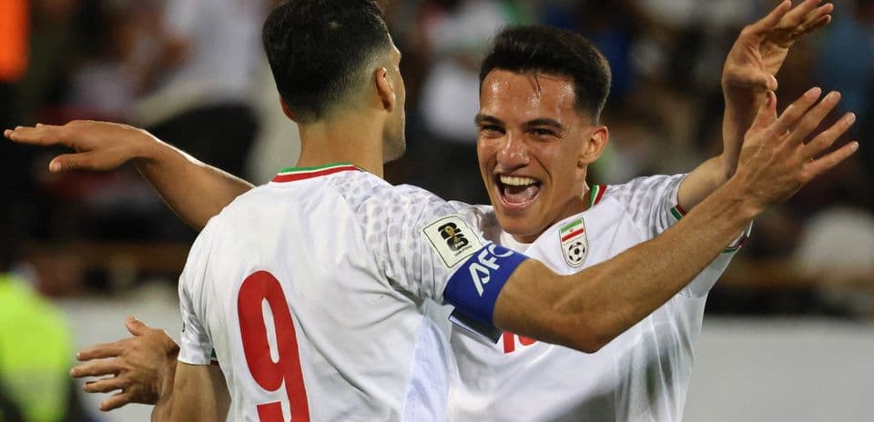 Two Iranian players celebrating a goal together