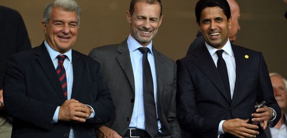 Three officials smiling in a stadium box