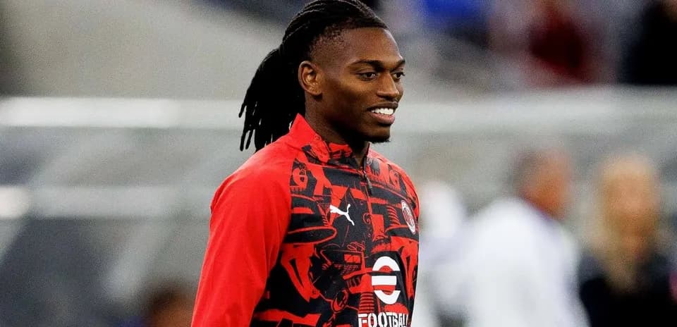 Player in red training kit smiling on the field