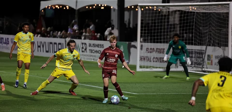 Players competing for the ball in USL Championship match