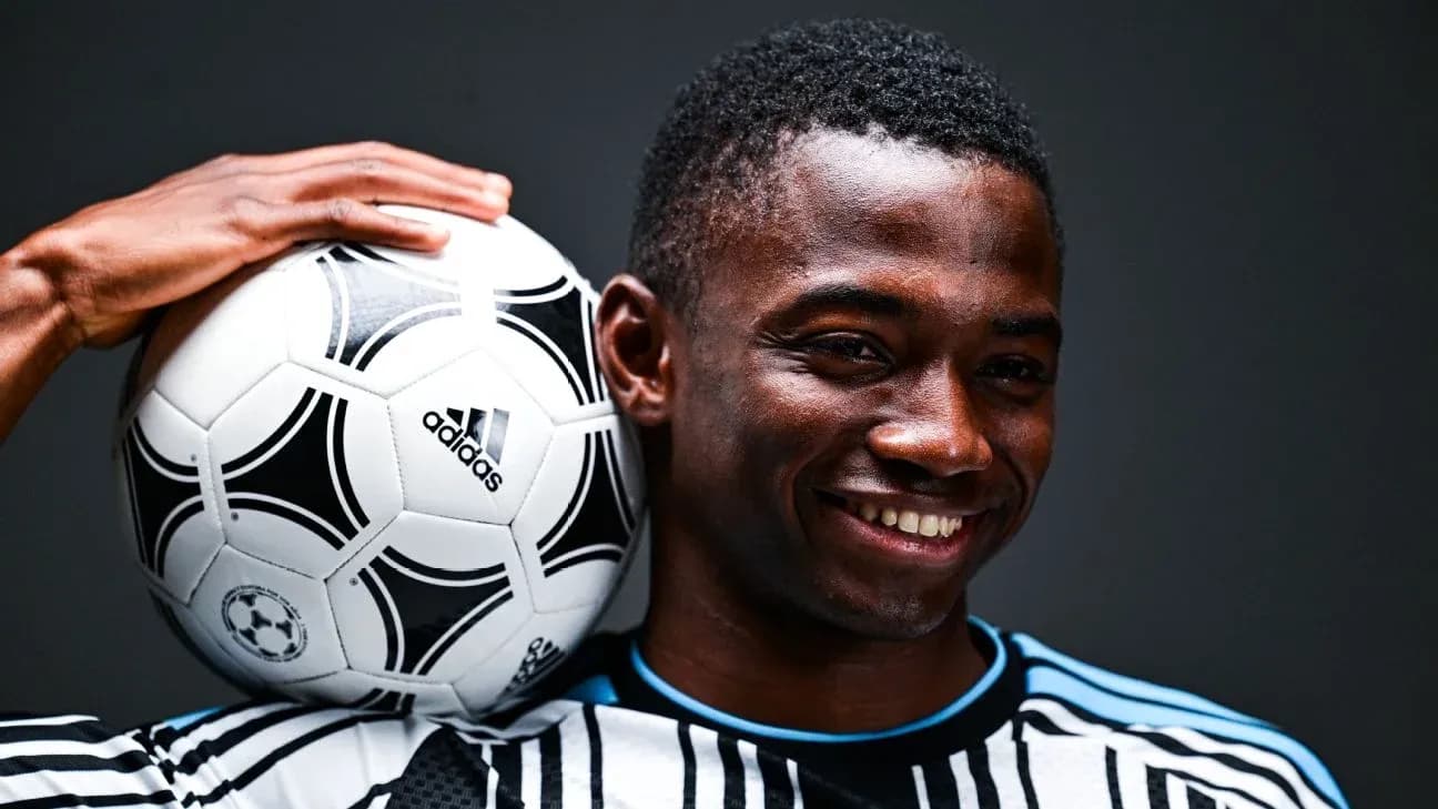 Player holding a soccer ball on shoulder