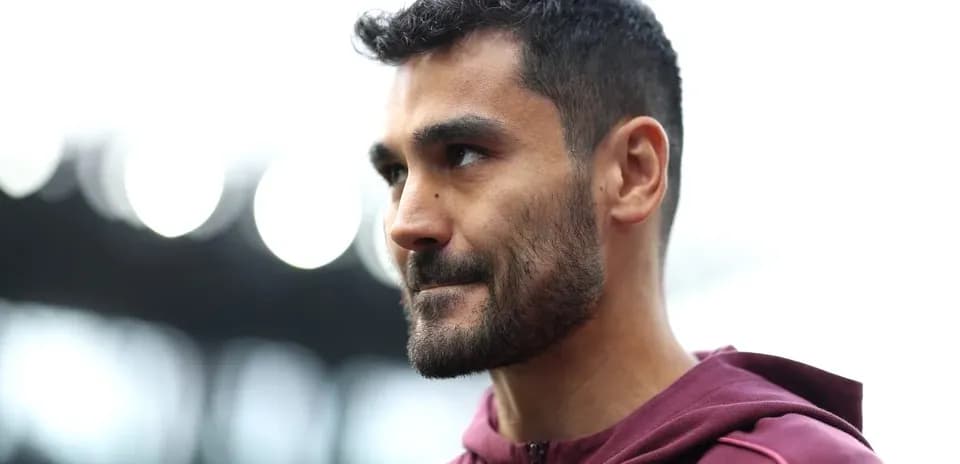 Player wearing maroon hoodie at stadium entrance