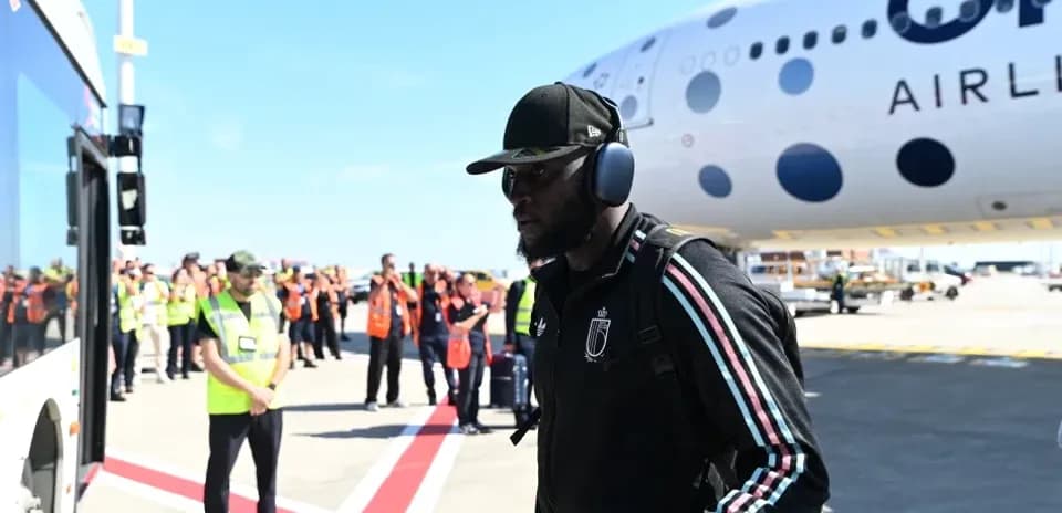 Player arriving at airport near airplane and staff