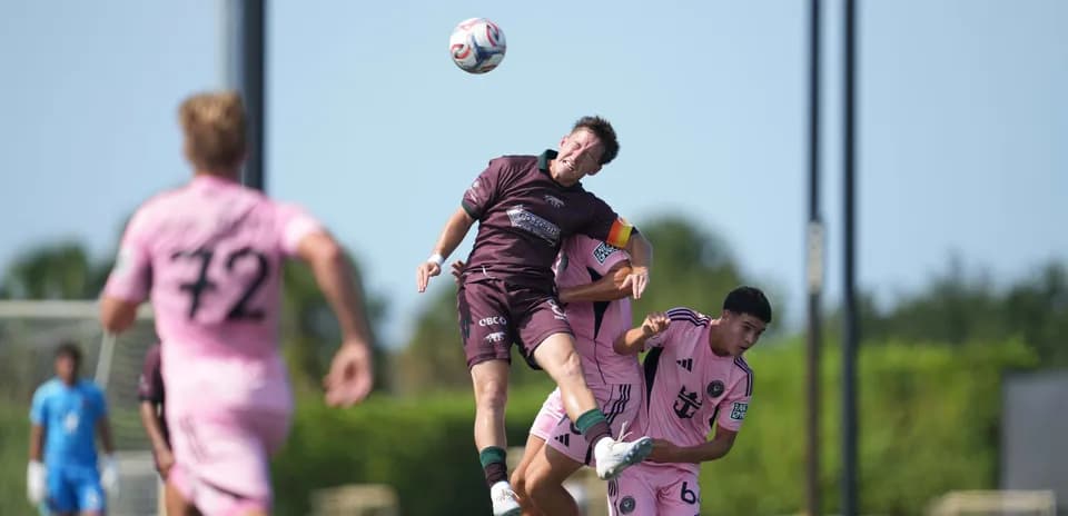 Players contesting a header during match