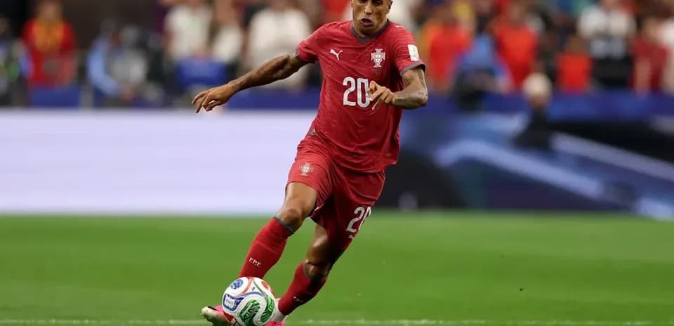 Player in red jersey running with soccer ball