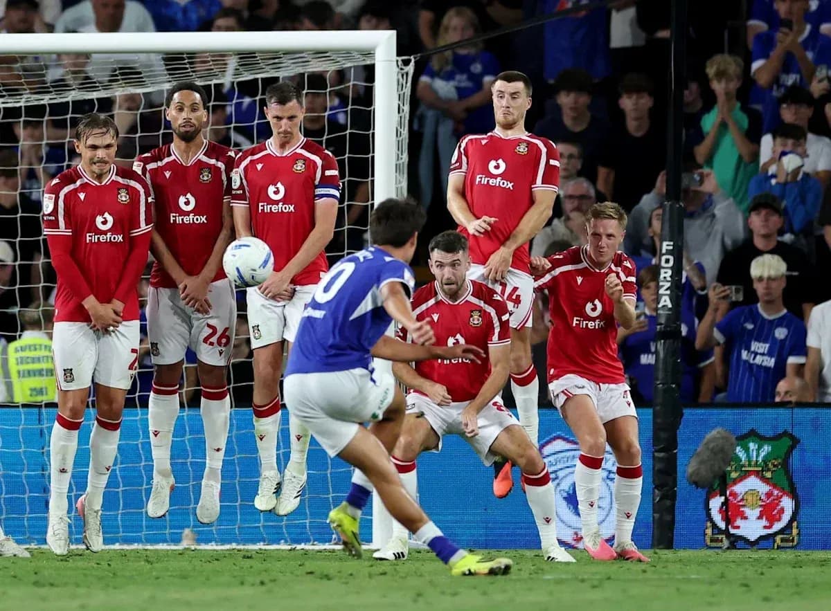 Player taking free kick while wall defends goal