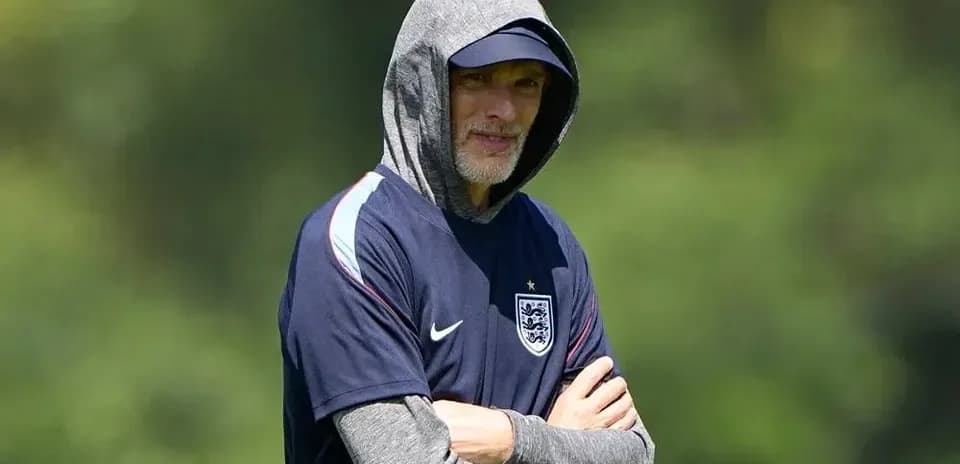 Coach in hoodie observing training session outdoors