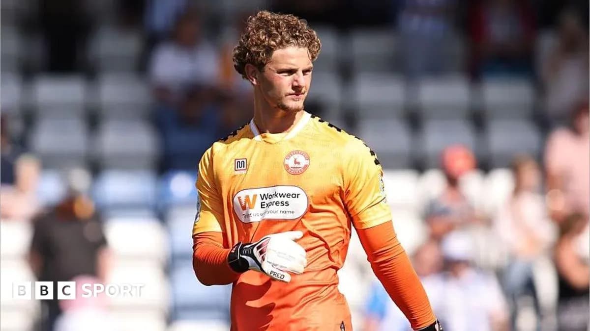 Goalkeeper in orange kit during match warm-up