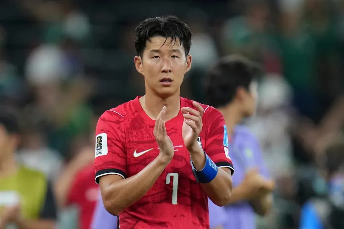 Player in red jersey applauding fans after match