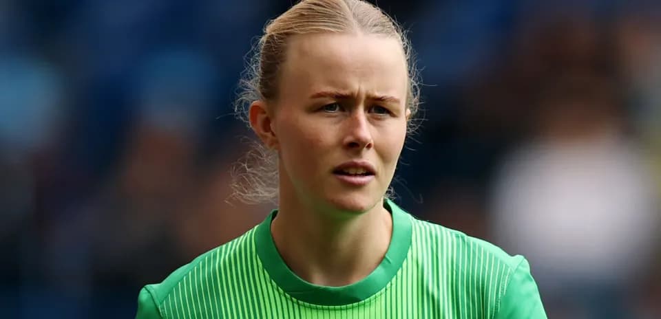 Female goalkeeper wearing green kit during match