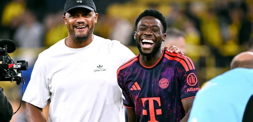 Two men laughing on football pitch after match
