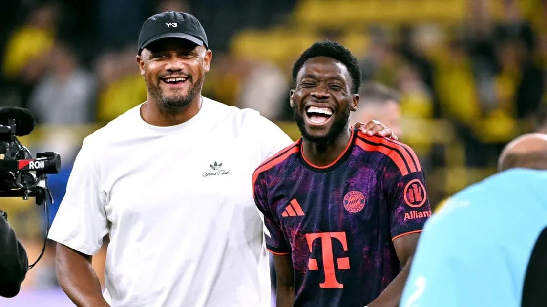 Two men laughing on football pitch after match