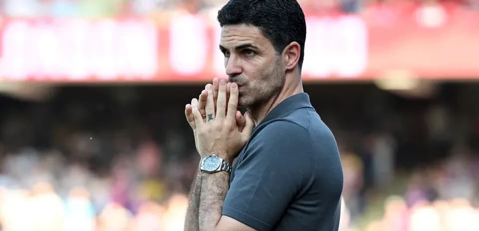 Coach observing match with hands clasped in front