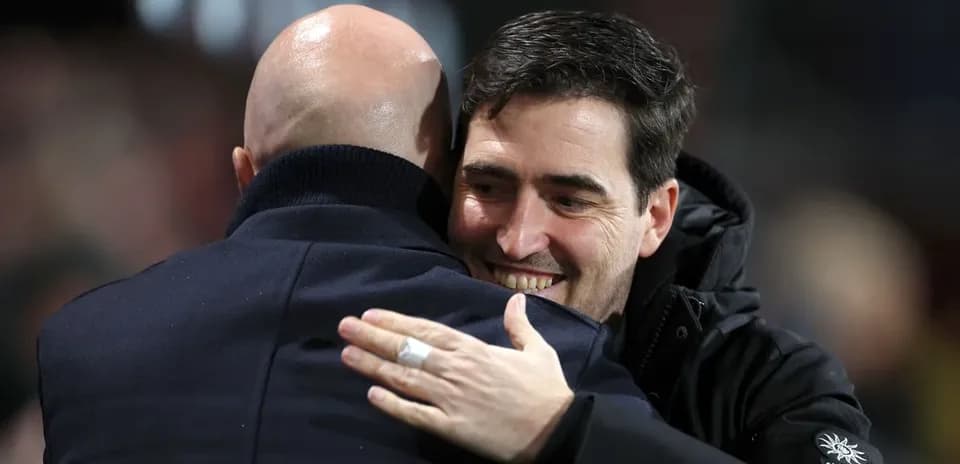 Two coaches embracing on the sidelines