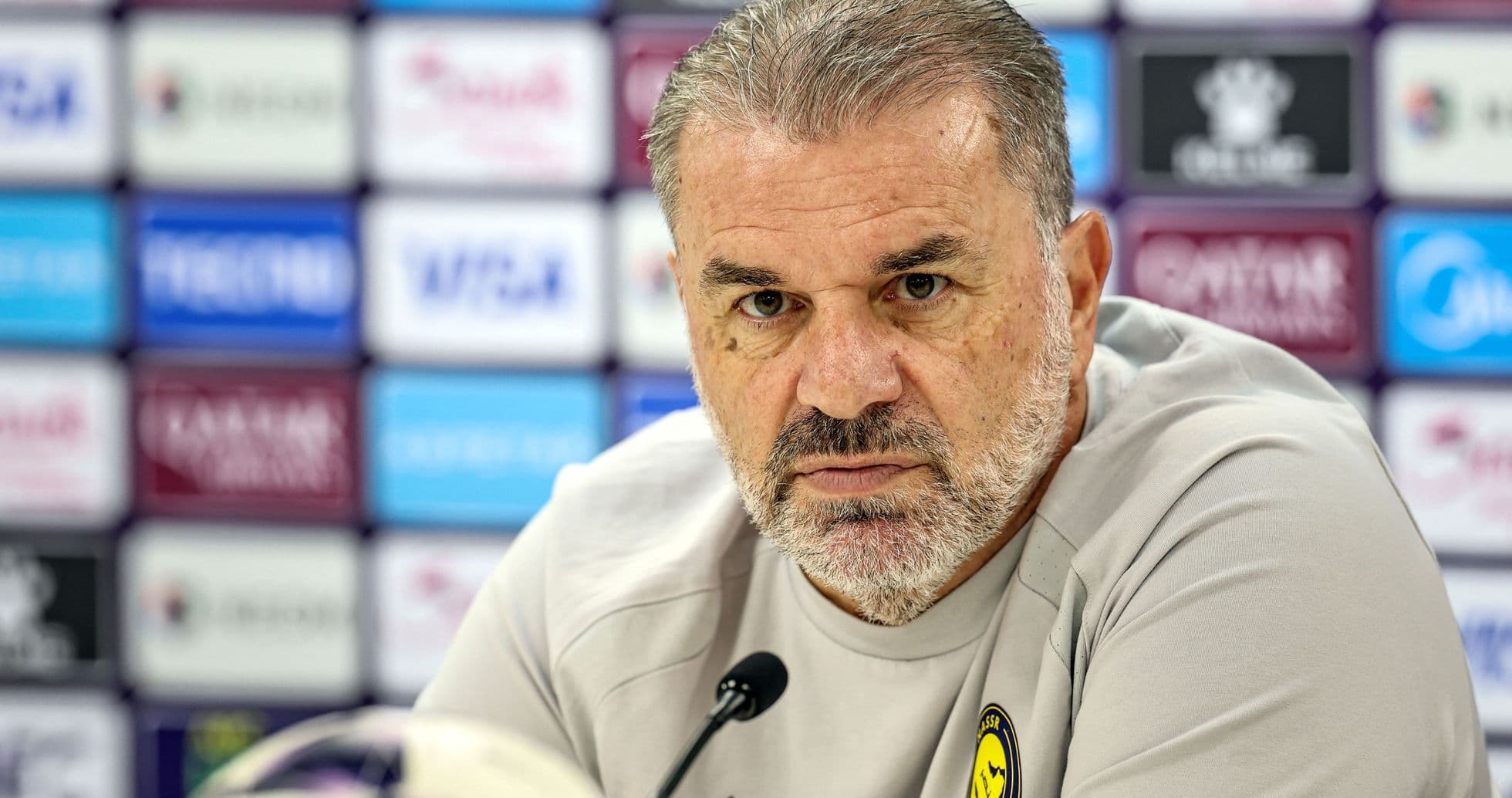 Manager at press conference with team logo visible