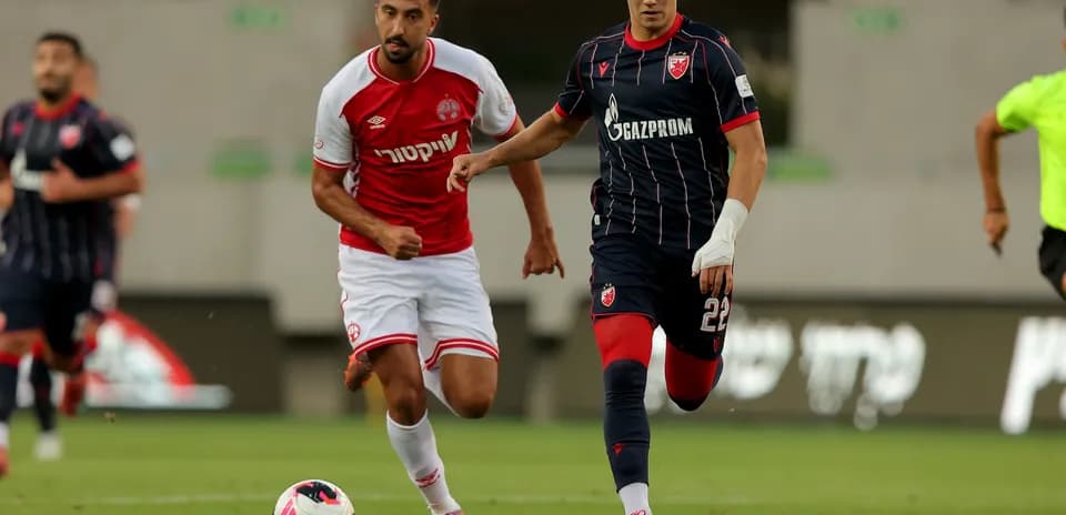 Crvena Zvezda player dribbling past Hapoel Beer Sheva player