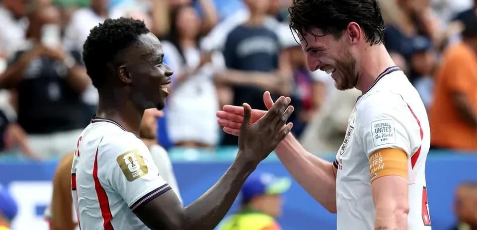 Two players celebrating with a handshake on the field