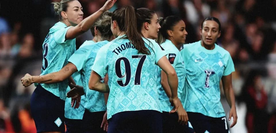 Women's football team celebrating together on the field