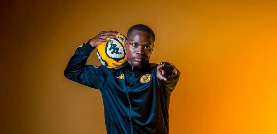 Player holding soccer ball and pointing at camera