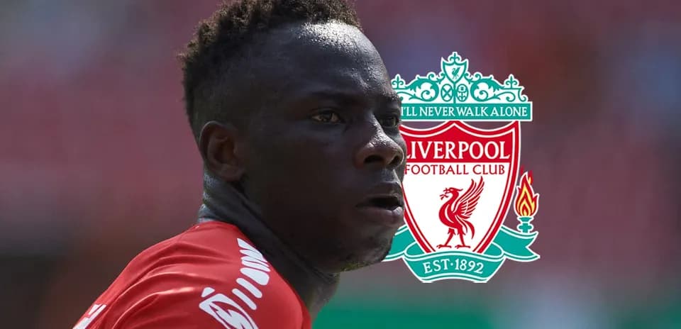 Player in red jersey with Liverpool logo background