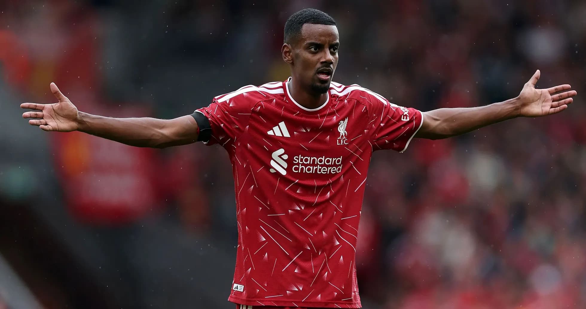 Player gesturing during match in Liverpool kit