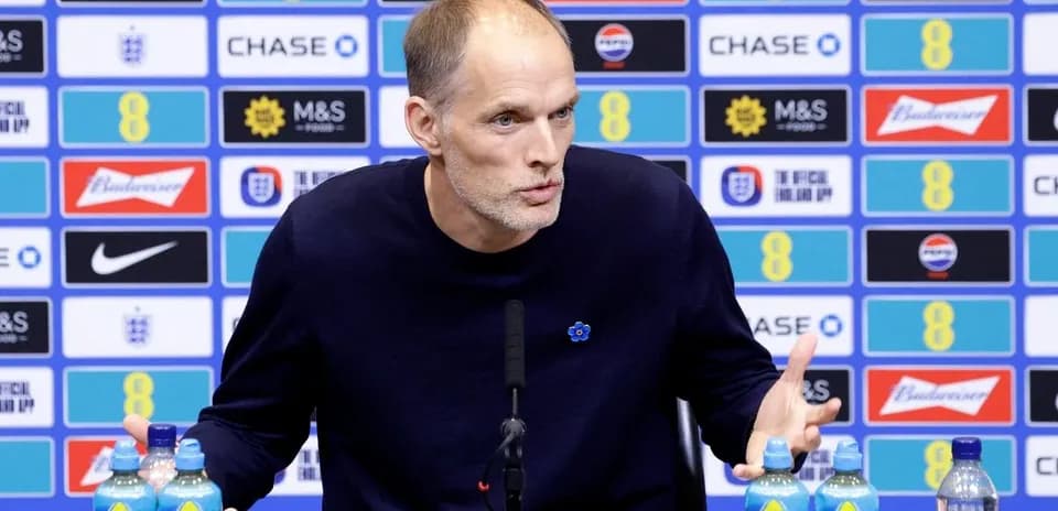 Manager speaking at press conference with water bottles