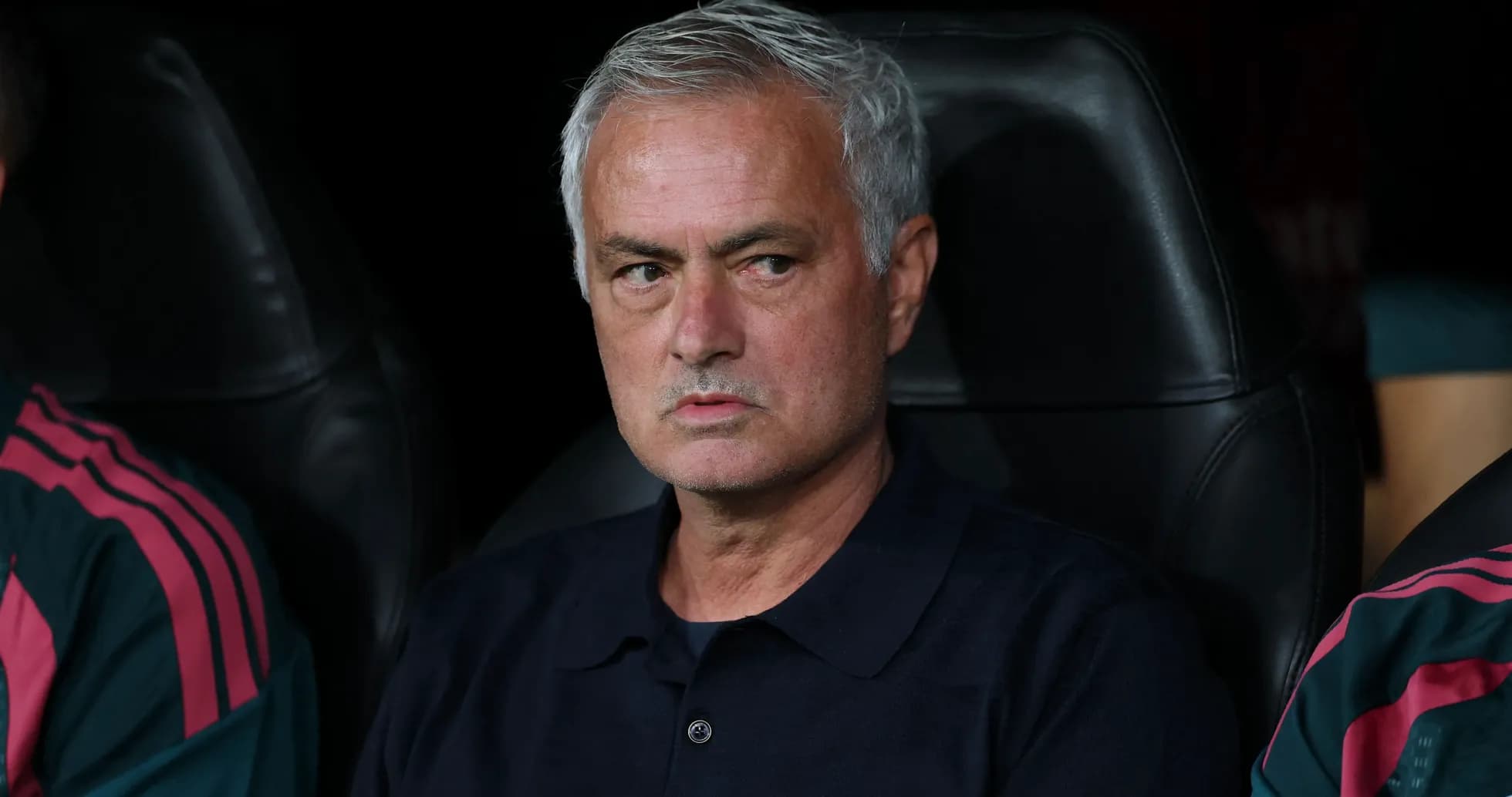 Coach seated on bench during a match