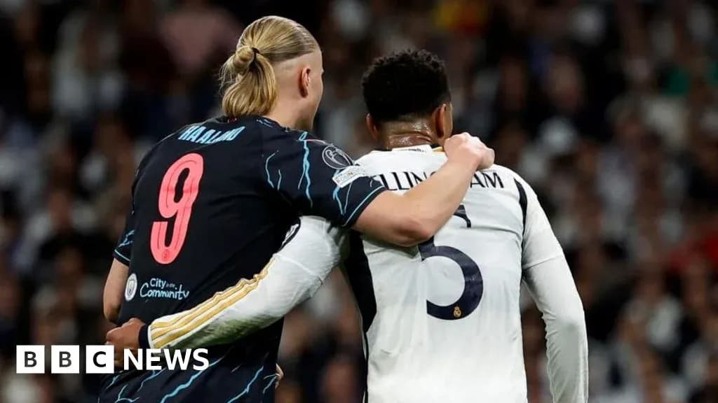 Two football players embracing on the pitch